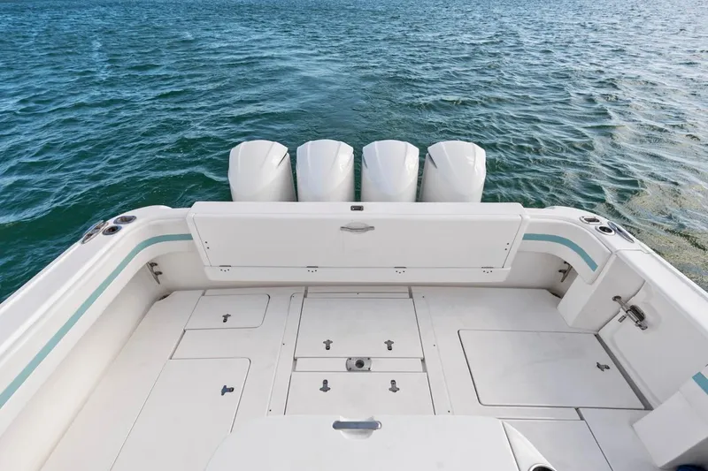Slide: The Image of 2018 Intrepid 475 Sport Yacht deck with triple outboard motors on open water. - 21