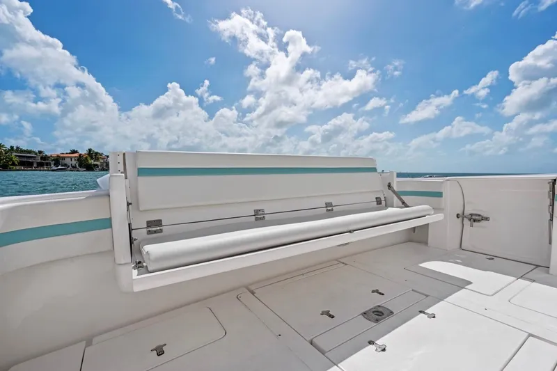Slide: The Image of 2018 Intrepid 475 Sport Yacht deck with seating, under a bright blue sky. - 27