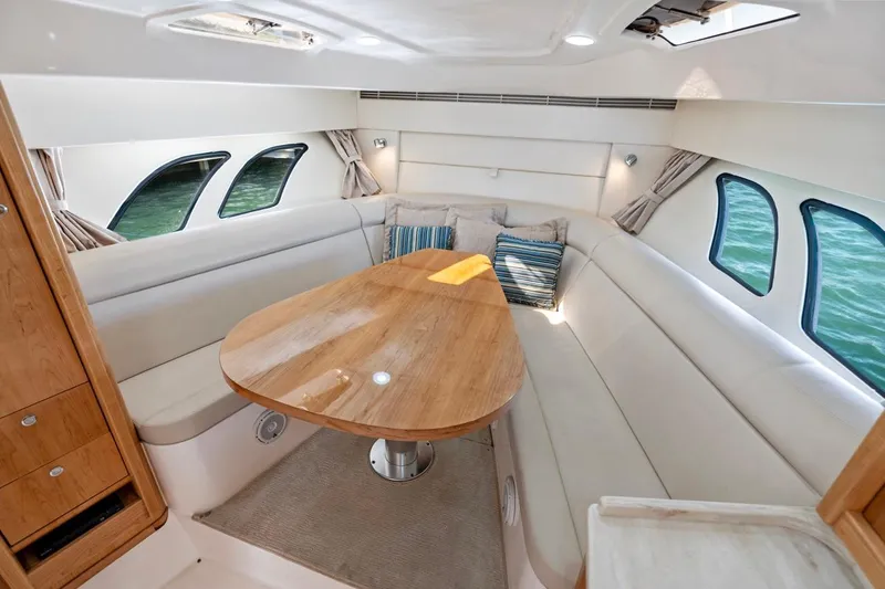 Slide: The Image of Interior of 2018 Intrepid 475 Sport Yacht with elegant seating and wooden table. - 44