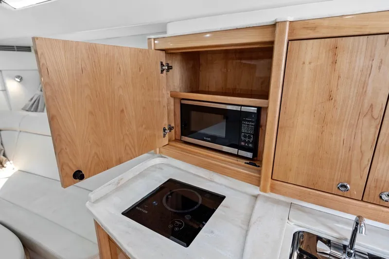Slide: The Image of 2018 Intrepid 475 Sport Yacht kitchen with microwave and stovetop. - 47
