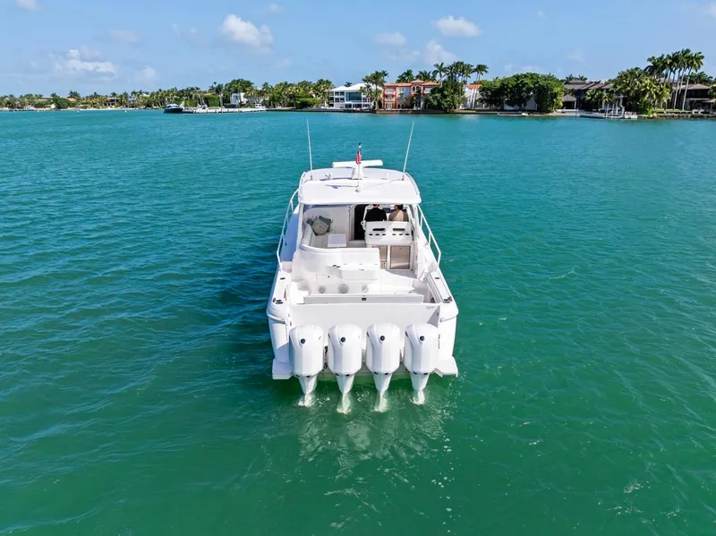 Slide: The Image of 2018 Intrepid 475 Sport Yacht on turquoise water, rear view with four engines. - 5