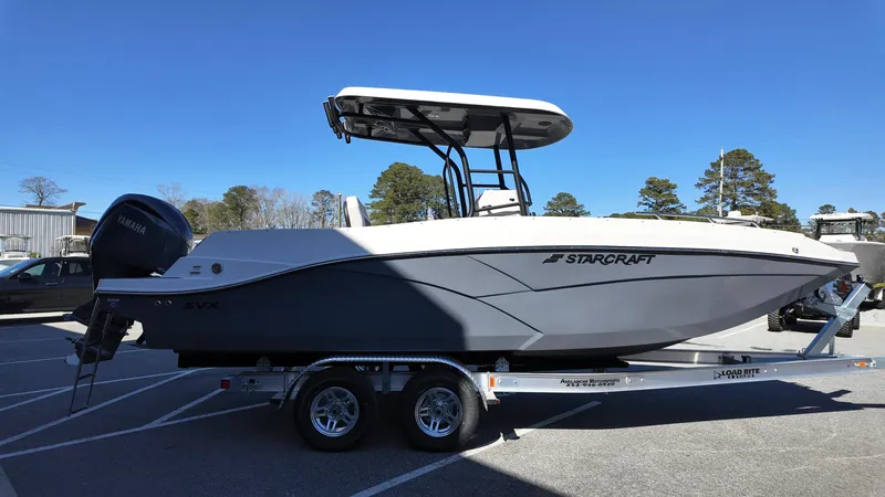 Slide: The Image of 2025 Starcraft SVX 231 OB CC boat on trailer, parked outdoors under clear sky. - 4