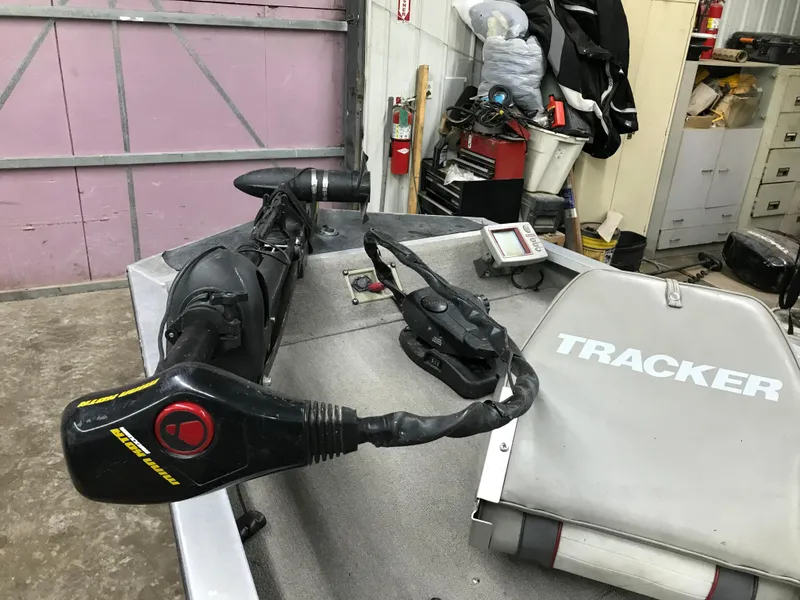 Slide: The Image of 1997 Bass Tracker Pro Team 175 boat interior with motor and seat in a garage. - 10