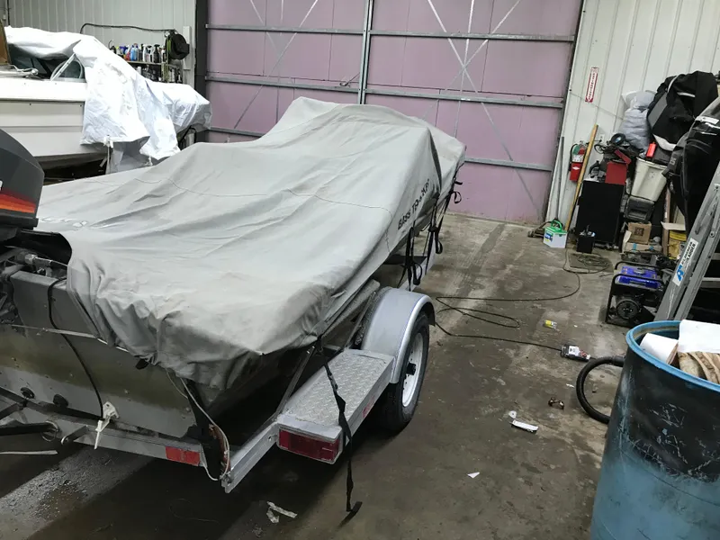 Slide: The Image of 1997 Bass Tracker Pro Team 175 boat covered in a garage. - 15