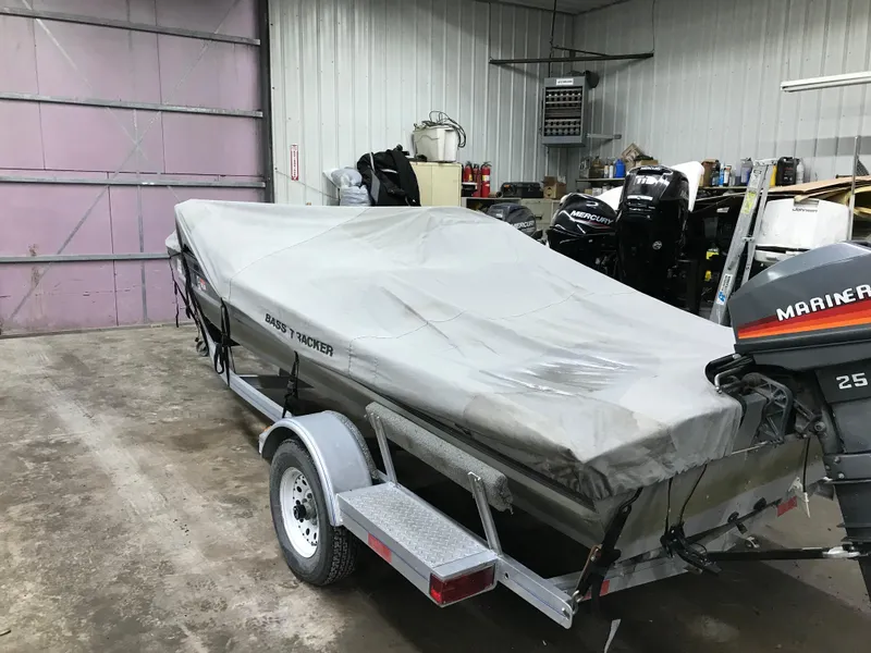 Slide: The Image of 1997 Bass Tracker Pro Team 175 boat covered in a garage with Mariner 25 outboard motor. - 16