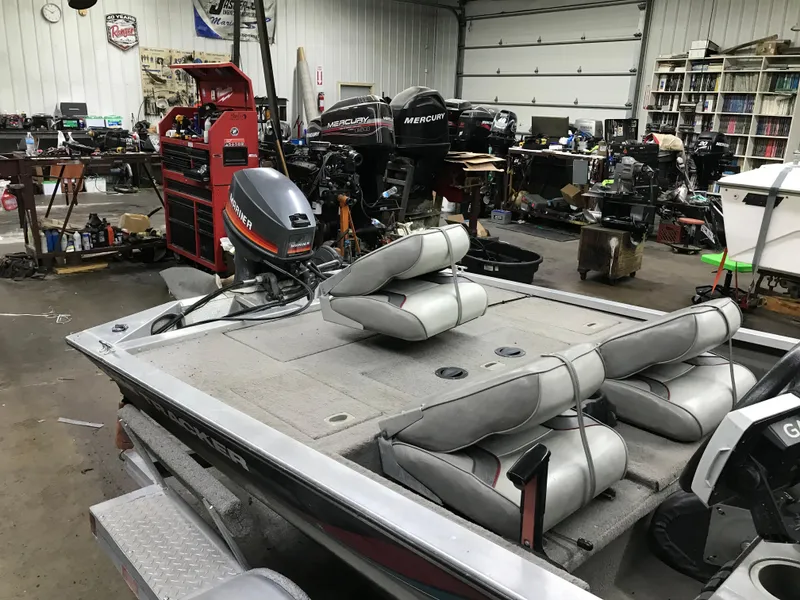 Slide: The Image of 1997 Bass Tracker Pro Team 175 boat in a workshop with tools and equipment. - 4