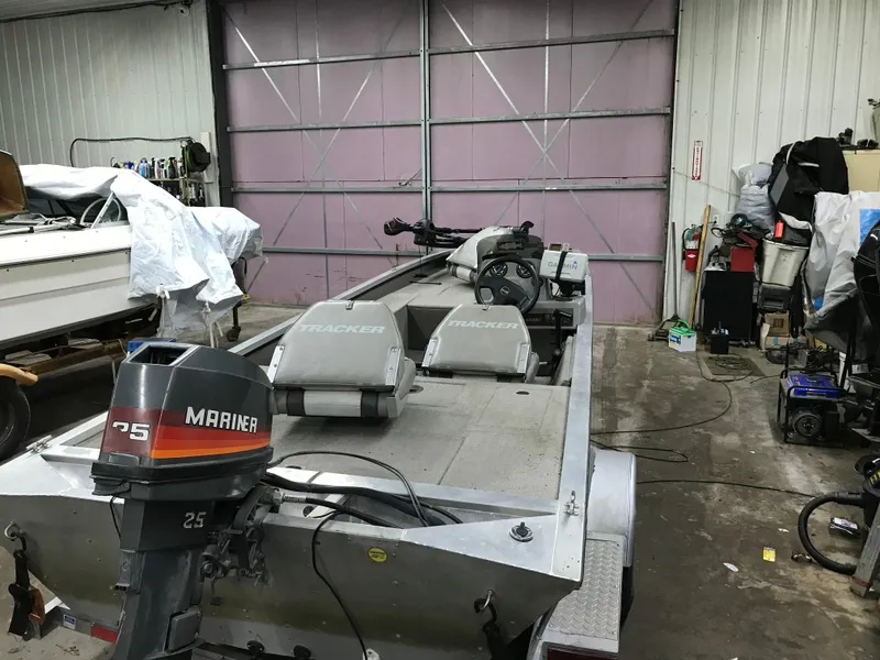 Slide: The Image of 1997 Bass Tracker Pro Team 175 boat in a garage with Mariner 25 outboard motor. - 5