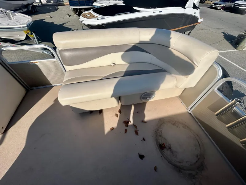 Slide: The Image of 2016 Godfrey SWEETWATER 200 boat interior with beige seating and debris on the floor. - 5