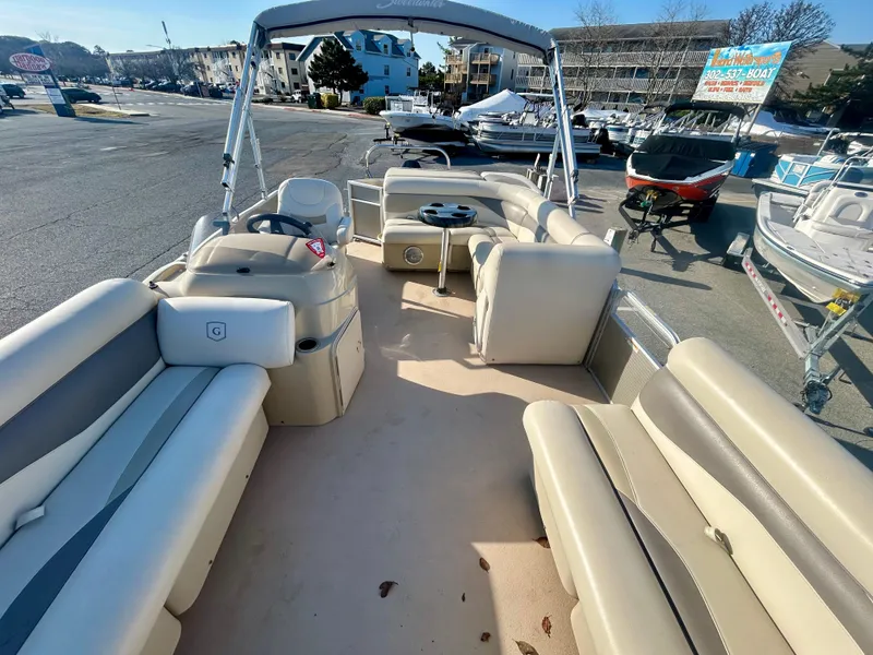 Slide: The Image of 2016 Godfrey SWEETWATER 200 pontoon boat with spacious seating and helm, parked outdoors. - 7