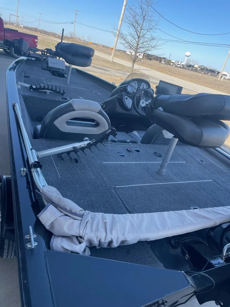 Slide: The Image of 2020 Tracker PT175 boat interior with steering wheel and seating, parked outdoors. - 5