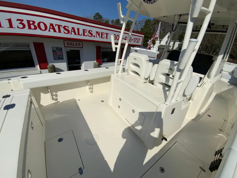Slide: The Image of 2025 Cobia 320 Center Console boat at dealership, showcasing spacious deck and seating. - 12