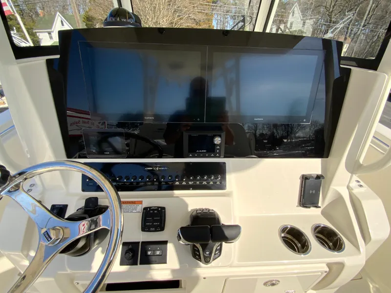 Slide: The Image of 2025 Cobia 320 Center Console dashboard with dual screens and steering wheel. - 14