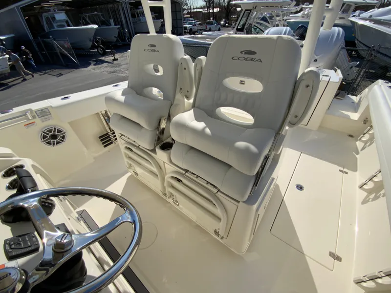 Slide: The Image of 2025 Cobia 320 Center Console boat interior with dual cushioned seats and steering wheel. - 15