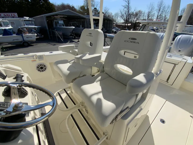 Slide: The Image of 2025 Cobia 320 Center Console boat with dual captain's chairs and steering wheel. - 16