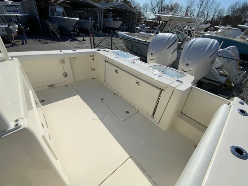 Slide: The Image of 2025 Cobia 320 Center Console boat with spacious deck and dual engines. - 17