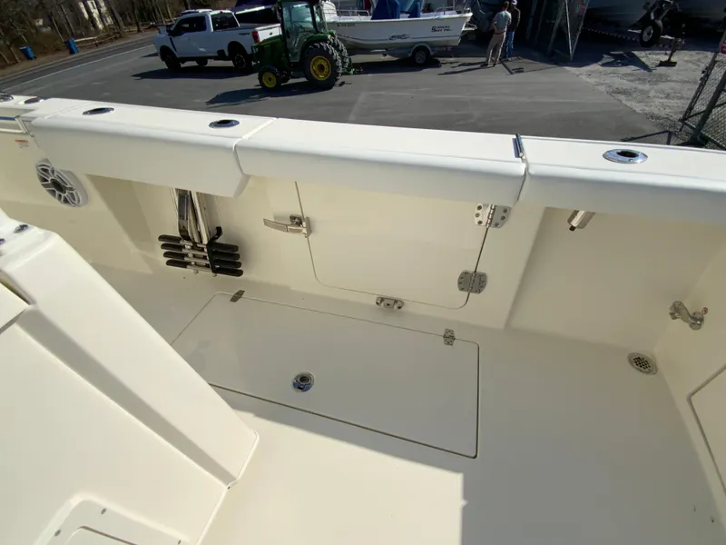 Slide: The Image of 2025 Cobia 320 Center Console boat interior with storage compartments and rod holders. - 21