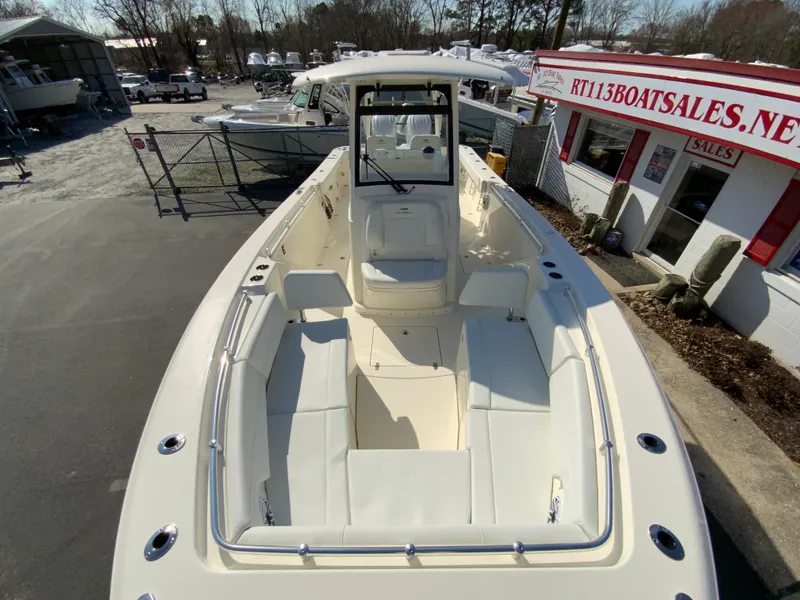 Slide: The Image of 2025 Cobia 320 Center Console boat at dealership, showcasing spacious seating and sleek design. - 29