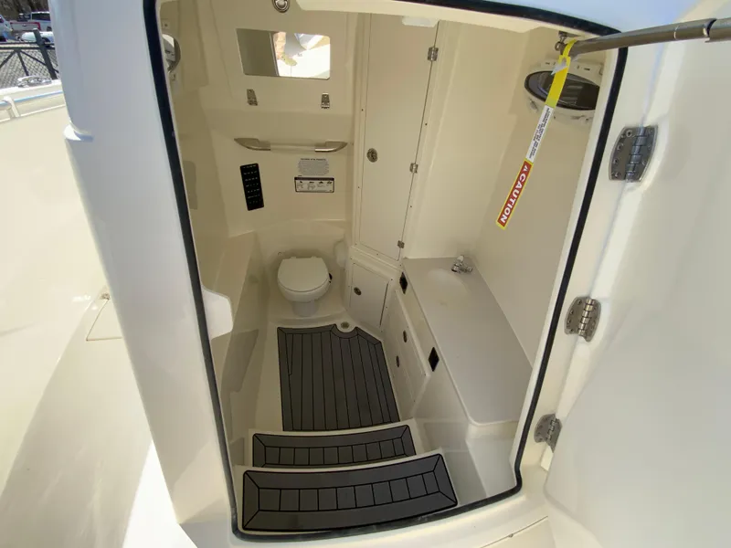Slide: The Image of 2025 Cobia 320 Center Console boat interior with toilet and storage compartments. - 35