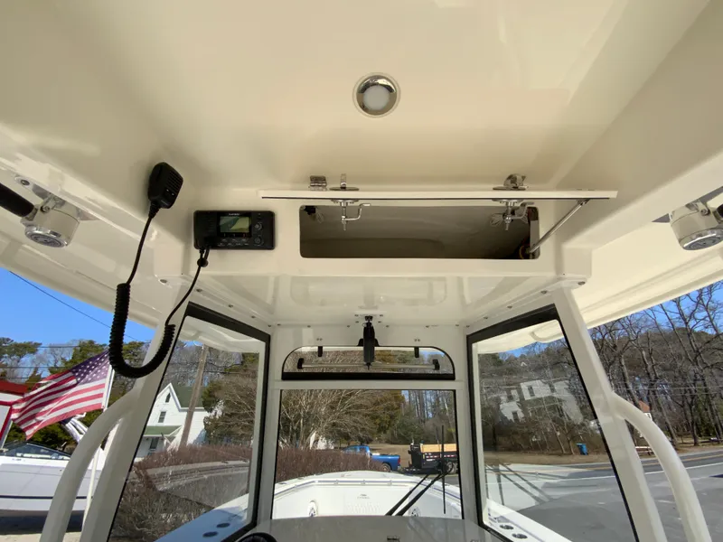 Slide: The Image of 2025 Cobia 320 Center Console boat interior with control panel and storage compartment. - 43