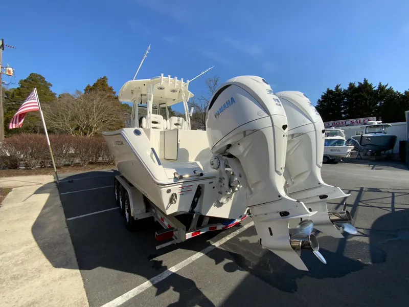 Slide: The Image of 2025 Cobia 320 Center Console boat with dual Yamaha engines on a trailer. - 8