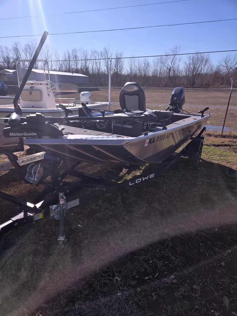 Slide: The Image of 2023 Lowe Skorpion 16 fishing boat on trailer, parked outdoors. - 2