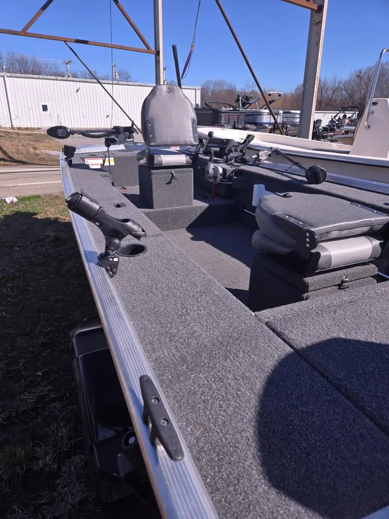 Slide: The Image of 2023 Lowe Skorpion 16 fishing boat with seating and rod holders, parked outdoors. - 7