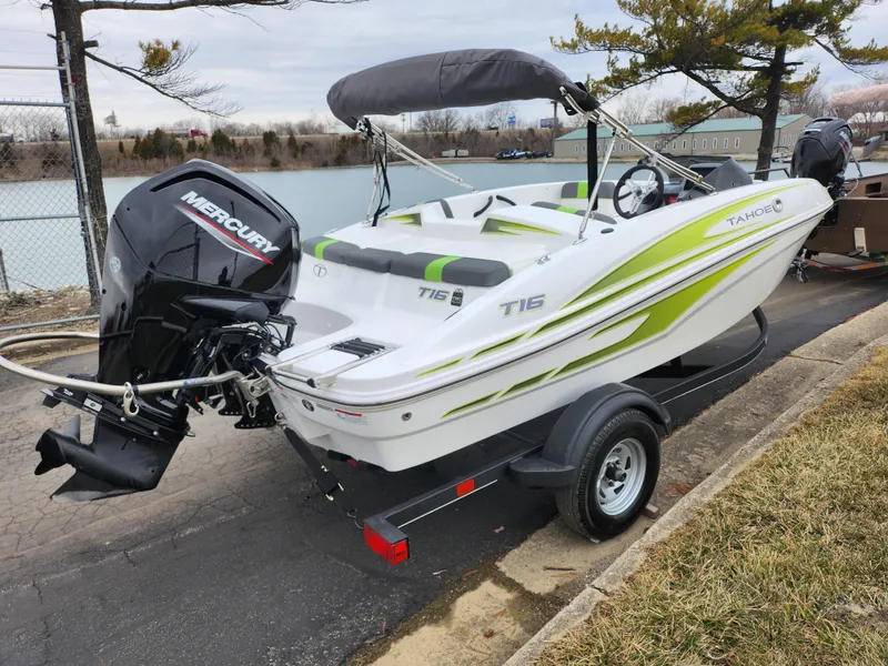 Slide: The Image of 2023 Tahoe T16 boat with Mercury engine on trailer by a lakeside. - 1