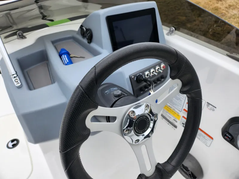 Slide: The Image of 2023 Tahoe T16 boat dashboard with steering wheel and control panel. - 12
