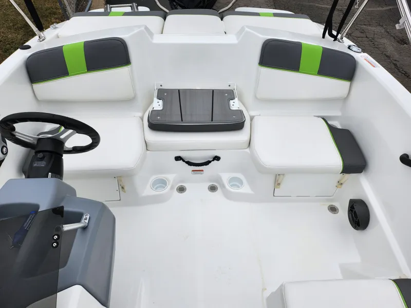 Slide: The Image of 2023 Tahoe T16 boat interior with white and green seating, steering wheel, and storage compartments. - 19