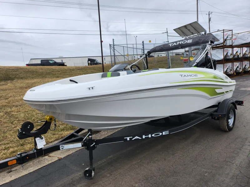 Slide: The Image of 2023 Tahoe T16 boat on trailer, white with green accents, parked outdoors. - 5