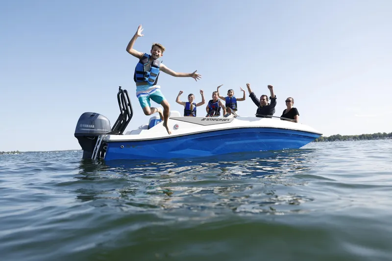 Slide: The Image of Group enjoying on a 2025 Starcraft SV 16 OB boat, with one person jumping into the water. - 5