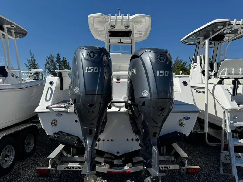 Slide: The Image of 2025 Tidewater 256 LXF boat with dual Yamaha 150 engines, parked on a trailer. - 4