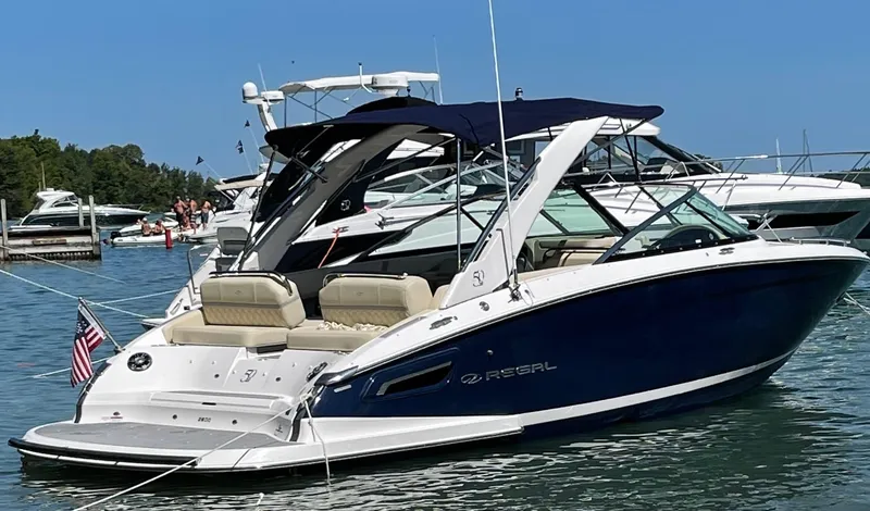 Slide: The Image of 2021 Regal 2800 Bowrider boat docked on a sunny day, featuring sleek design. - 2