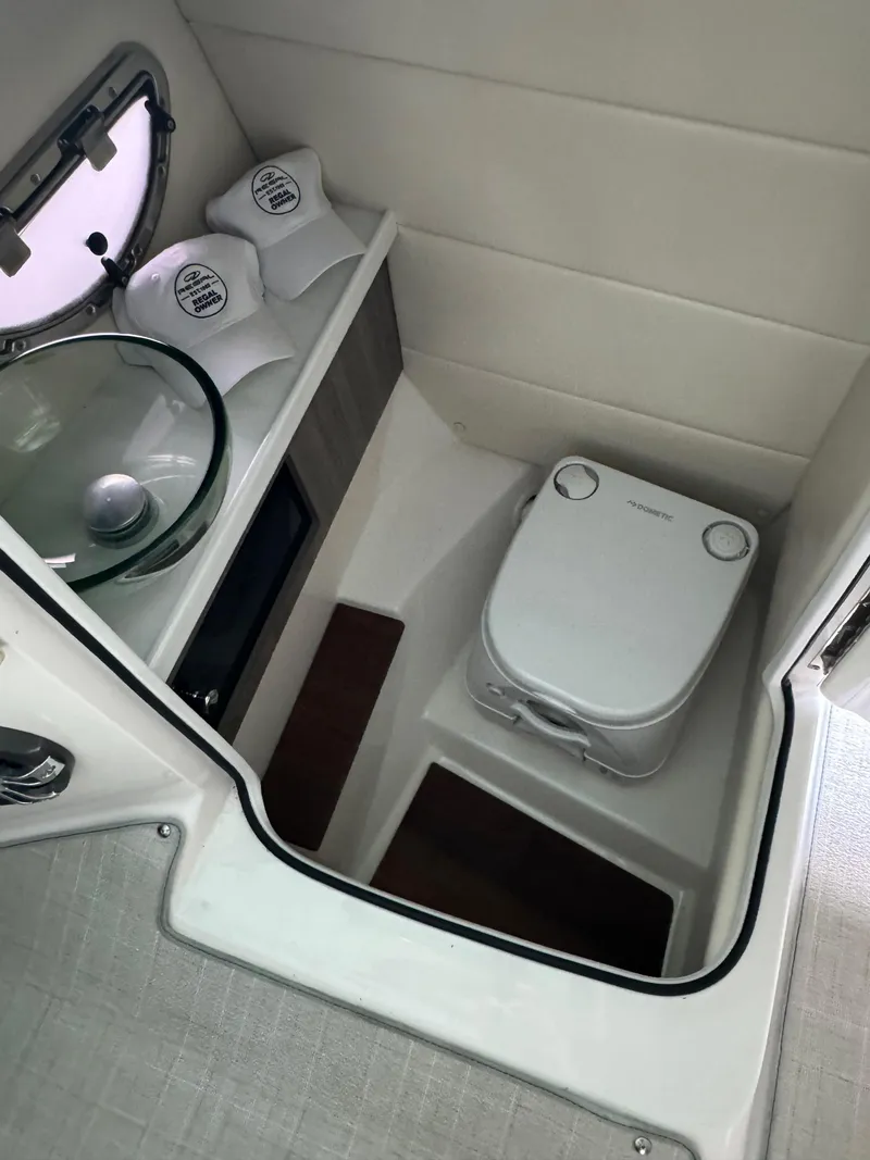 Slide: The Image of 2021 Regal 2800 Bowrider boat bathroom with modern amenities and compact design. - 21