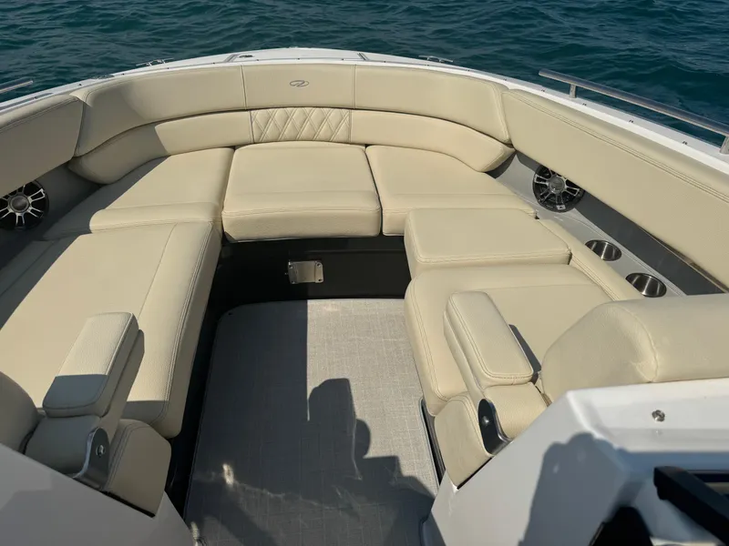Slide: The Image of 2021 Regal 2800 Bowrider interior with beige seating, on calm water. - 22