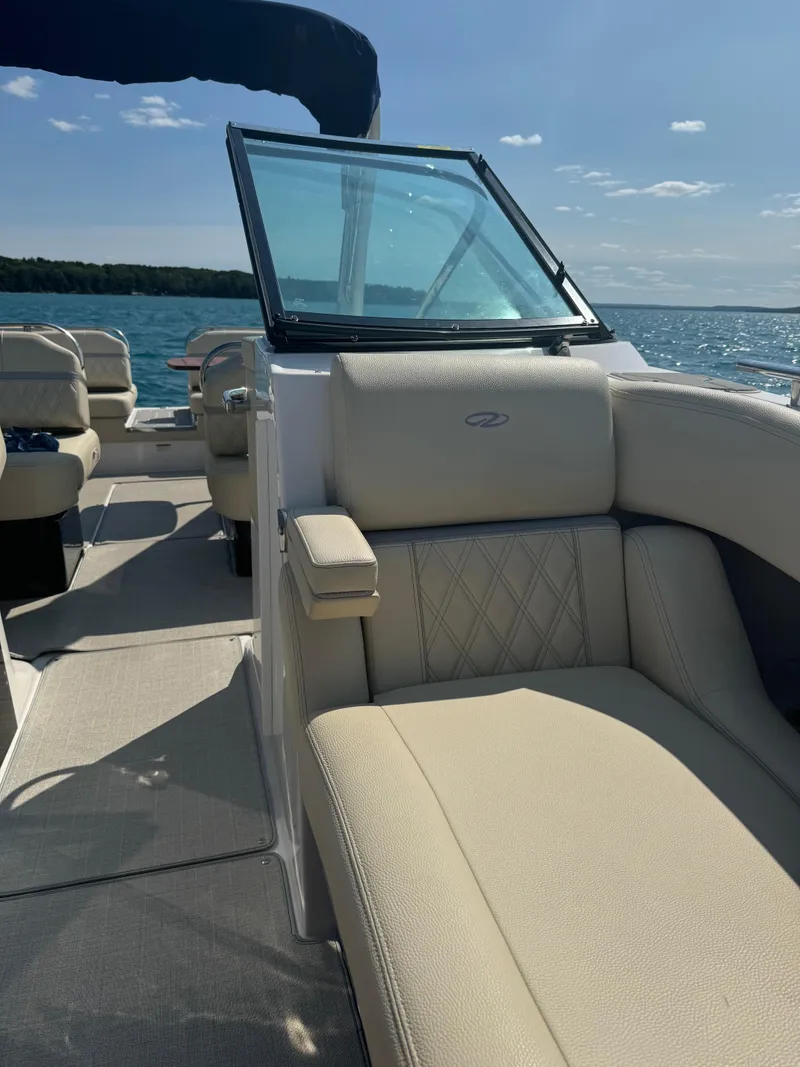 Slide: The Image of 2021 Regal 2800 Bowrider boat interior with beige seating on a sunny day. - 24