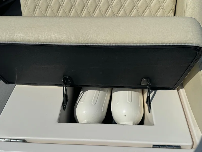 Slide: The Image of 2021 Regal 2800 Bowrider storage compartment with fenders under cushioned seat. - 28