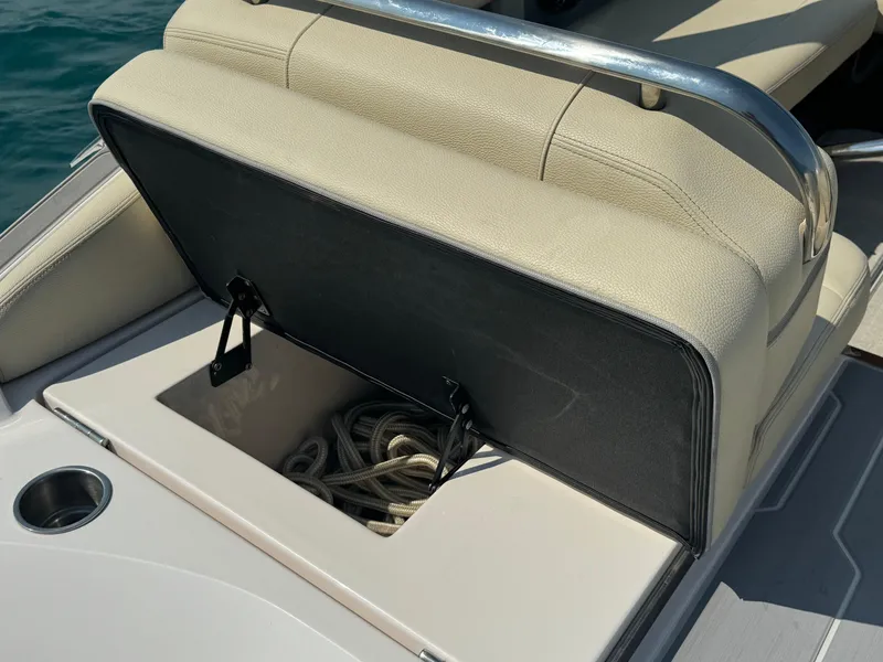 Slide: The Image of Open storage compartment on 2021 Regal 2800 Bowrider boat with beige seating. - 29