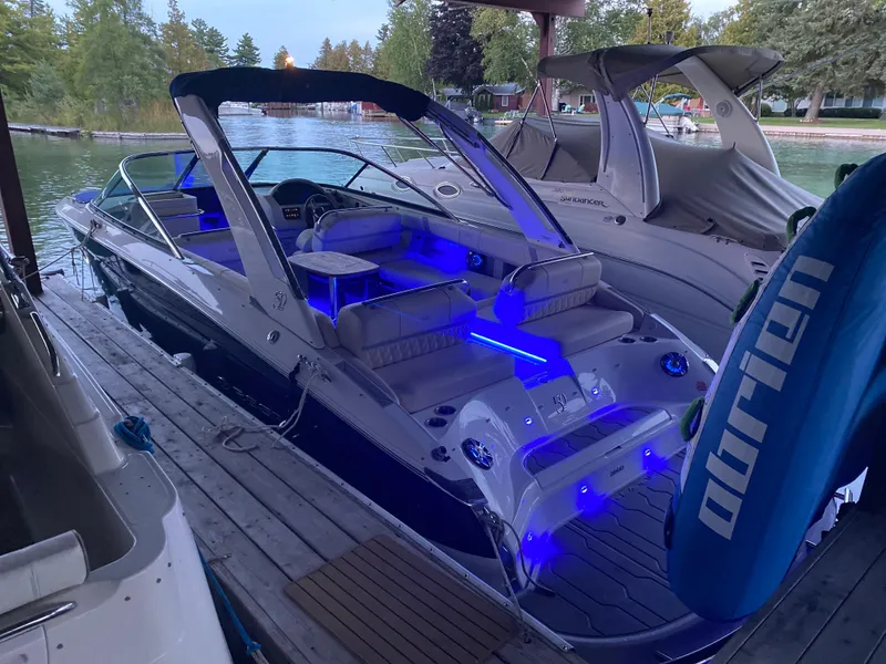 Slide: The Image of 2021 Regal 2800 Bowrider with blue LED lights docked by the water. - 3