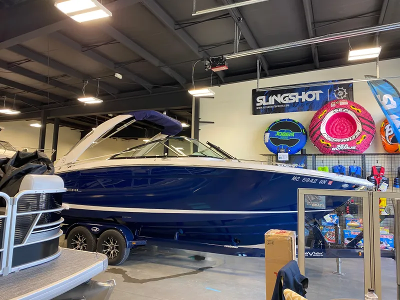 Slide: The Image of 2021 Regal 2800 Bowrider boat displayed indoors with water sports equipment. - 34