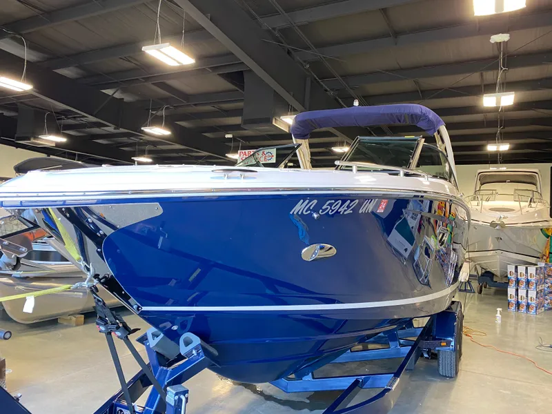 Slide: The Image of 2021 Regal 2800 Bowrider boat in showroom, blue hull, on trailer. - 35