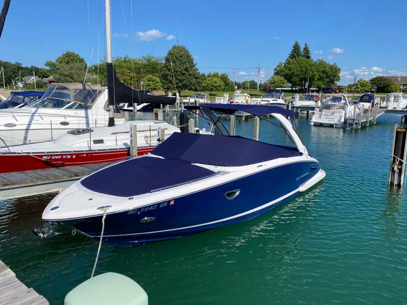 Slide: The Image of 2021 Regal 2800 Bowrider boat docked in a marina, covered and ready for use. - 5