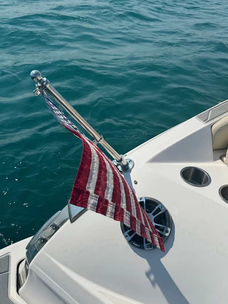 Slide: The Image of 2021 Regal 2800 Bowrider with American flag on calm water. - 9