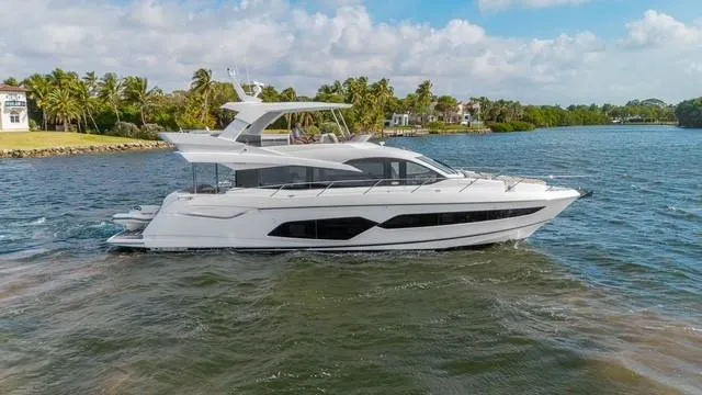 Slide: The Image of 2019 Sunseeker Manhattan 66 yacht cruising on a scenic waterway. - 5