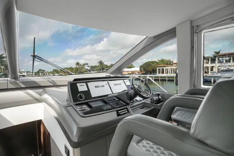 Slide: The Image of 2019 Sunseeker Manhattan 66 yacht cruising on a scenic waterway with lush greenery. - 8