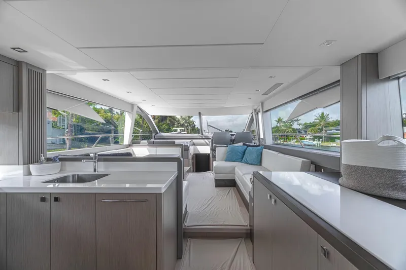 Slide: The Image of 2019 Sunseeker Manhattan 66 yacht cruising on a scenic waterway with palm trees. - 9