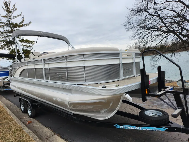 Slide: The Image of 2019 Bennington SX 22 Cruise and Fish pontoon boat on trailer by a lake. - 8
