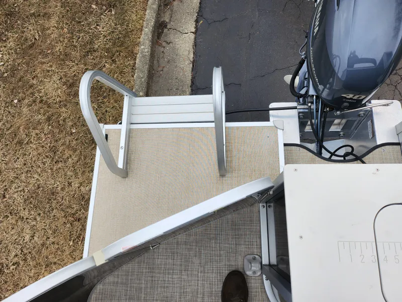 Slide: The Image of 2019 SunCatcher V16 Fish boat with ladder and motor, docked on pavement. - 17