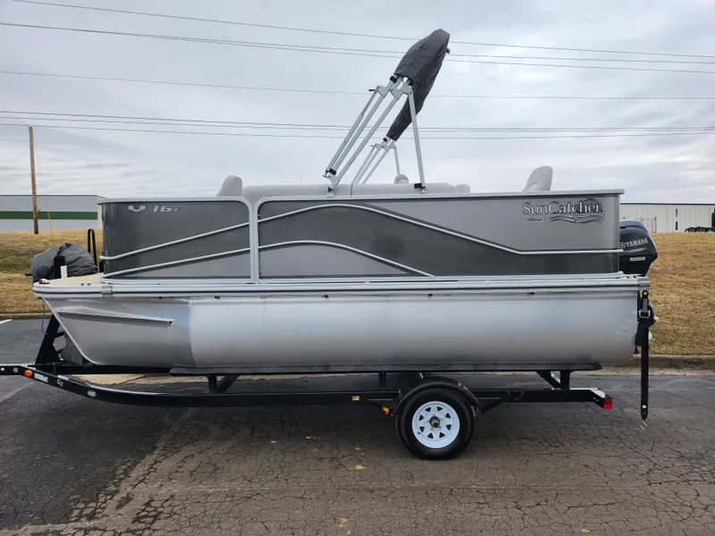 Slide: The Image of 2019 SunCatcher V16 Fish pontoon boat on trailer, side view, gray and silver design. - 4