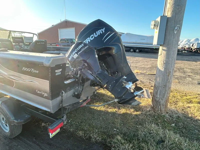 Slide: The Image of 2009 Lund 1950 Tyee Grand Sport boat with Mercury outboard motor, parked outdoors. - 3